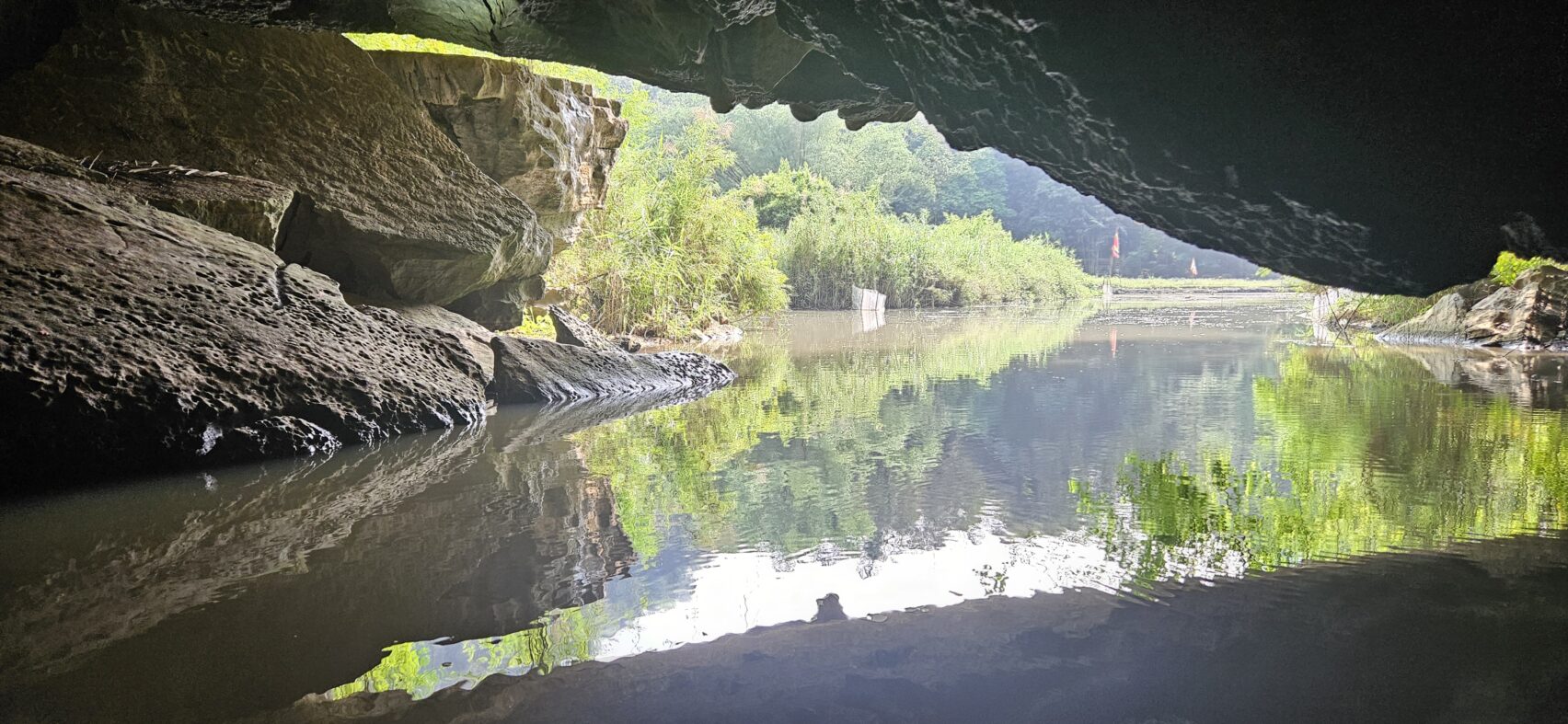Embarquement sur de petits sampans traditionnels pour une balade paisible sur une rivière avec ses paysages encore sauvages et déserts, au milieu de rizières (selon la saison), de grottes naturelles et de pitons calcaires