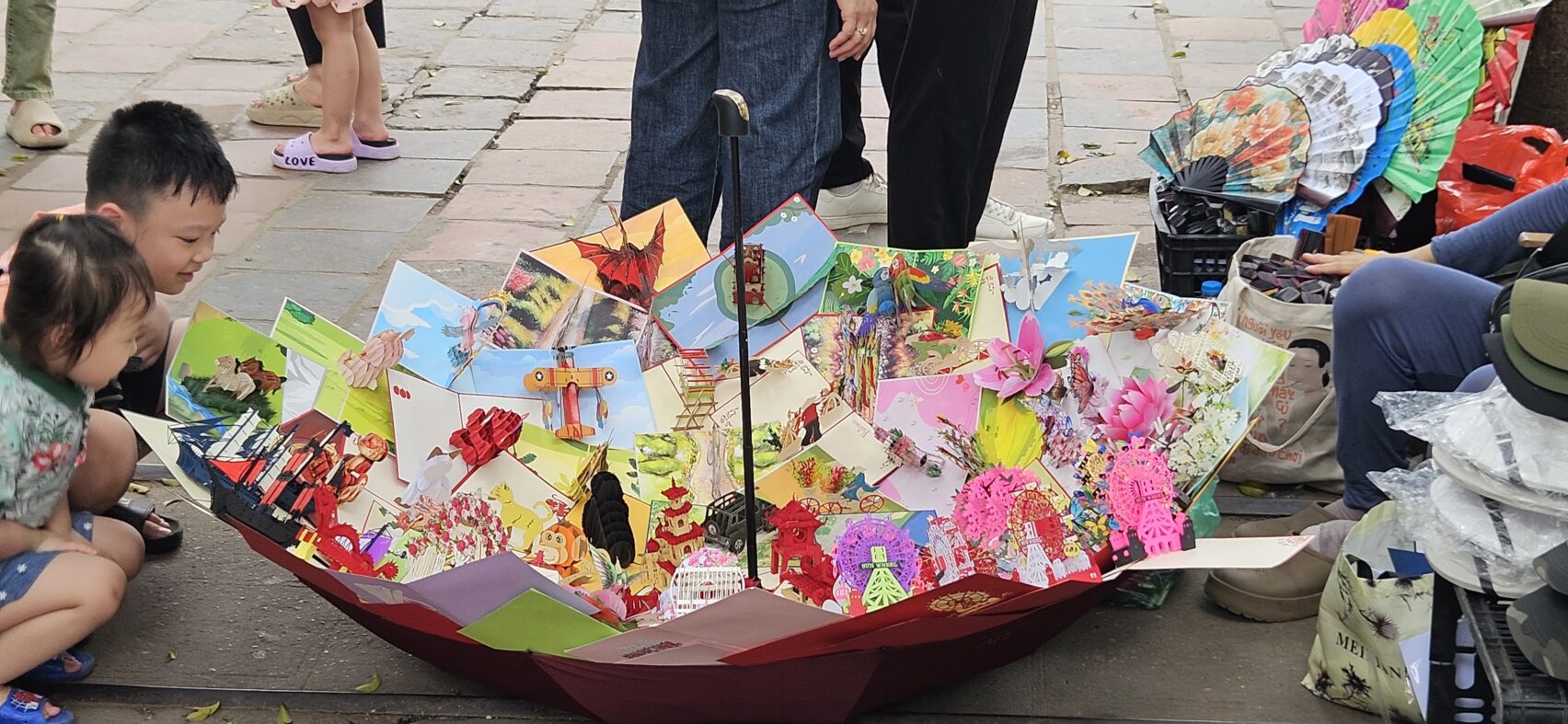 Vendeuse de cartes dans les rues de Hanoï au Vietnam dans un parapluie retourné