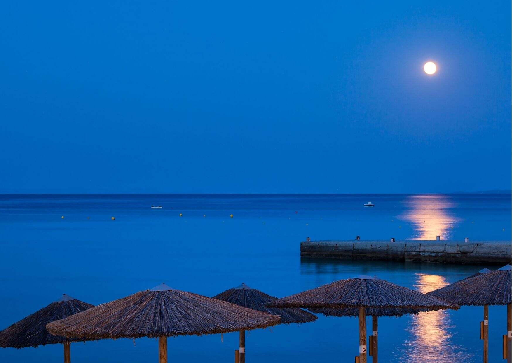 La pleine lune et le reflet dans la mer une vue paisible depuis votre hôtel Ammon Zeus 5 étoiles situé à Kallithea à Chalcidique en Grèce du nord