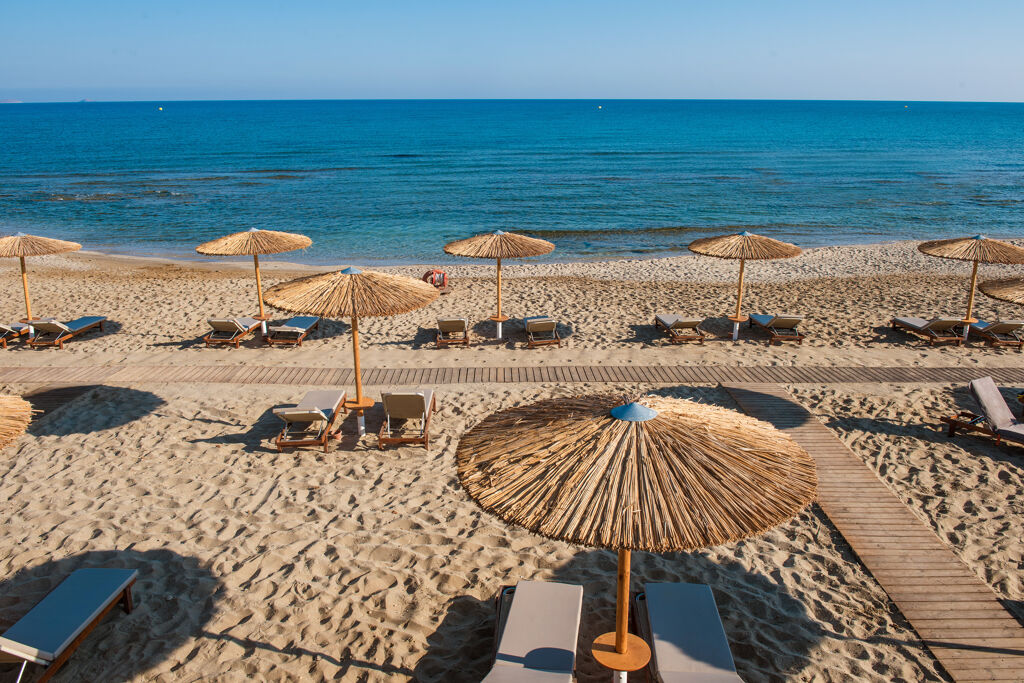 Plage de sable fin avec Parasols et lits de bain de l'hôtel Paralos Kosta Mare Resort en Crète du nord