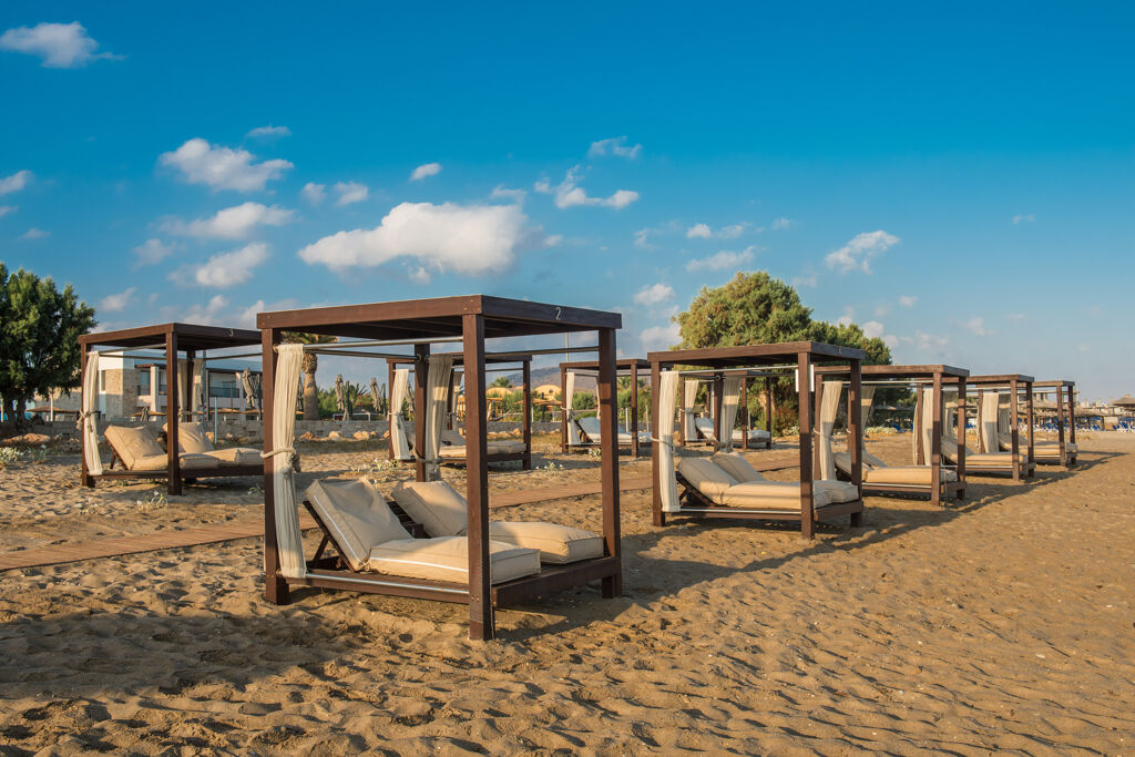 Plage de sable fin devant l'hôtel Paralos Kosta Mare Resort avec Bain de soleil double avec auvent et rideaux, en Crète du nord