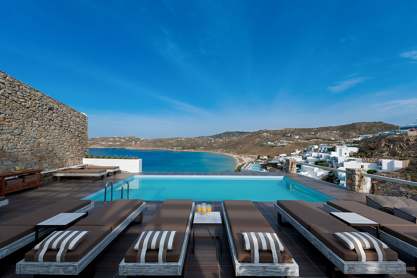 Vue bord de piscine et vue panoramique depuis une suite de l'hôtel Cova Mykonos Suites