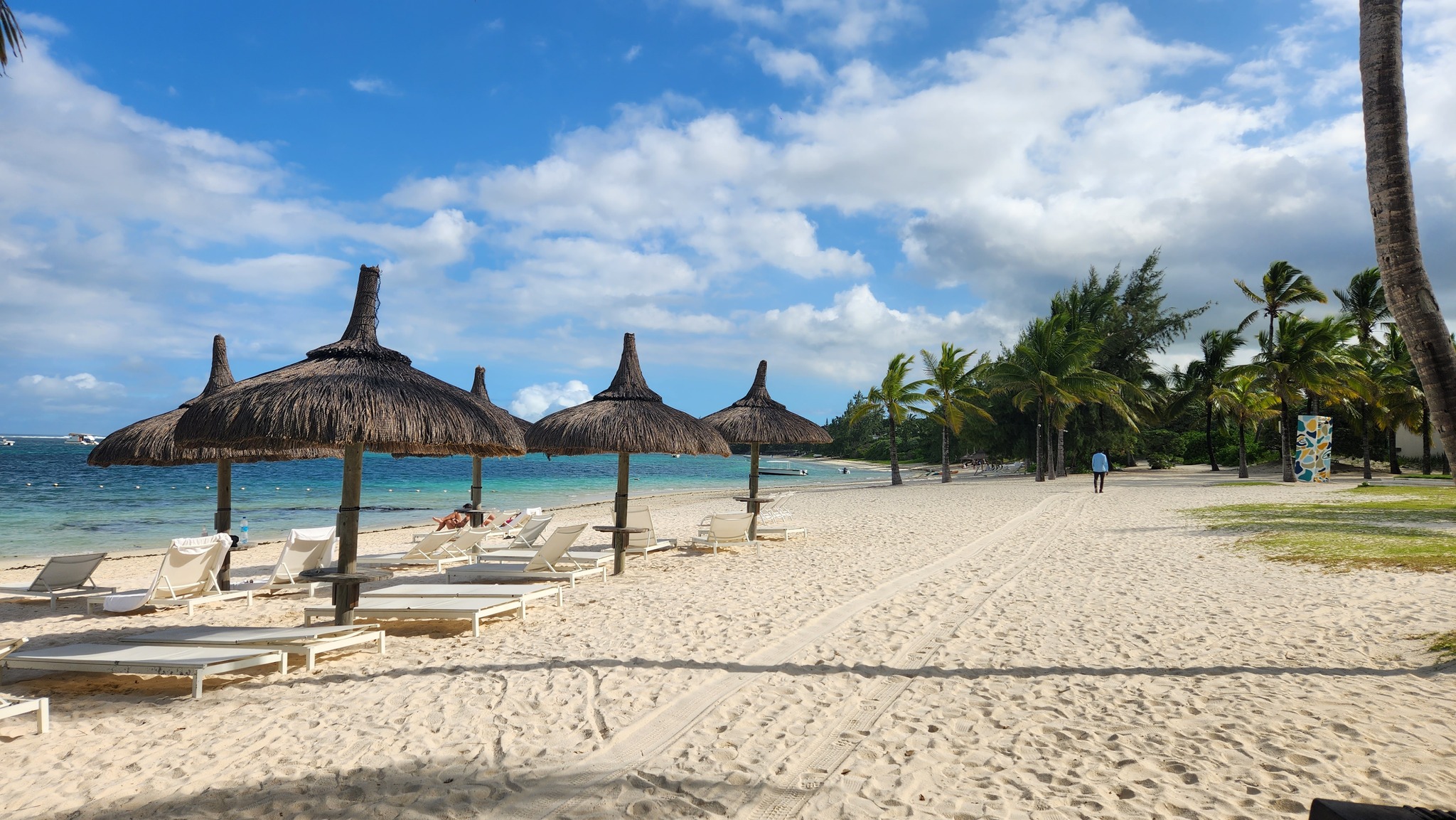 Transats avec parasols sur la plage de l'hôtel Long beach Luxury resort situé à l'île Maurice