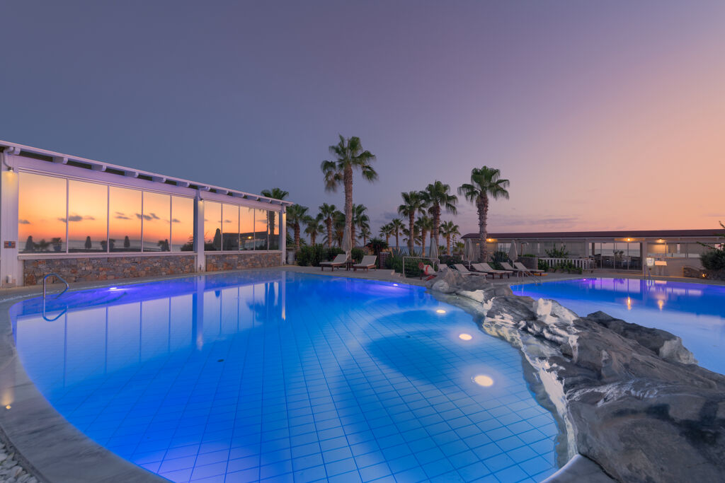 Piscine de nuit éclairée de l'hôtel Ikaros Beach Luxury Resort & Spa à Stalida en Crète Grèce